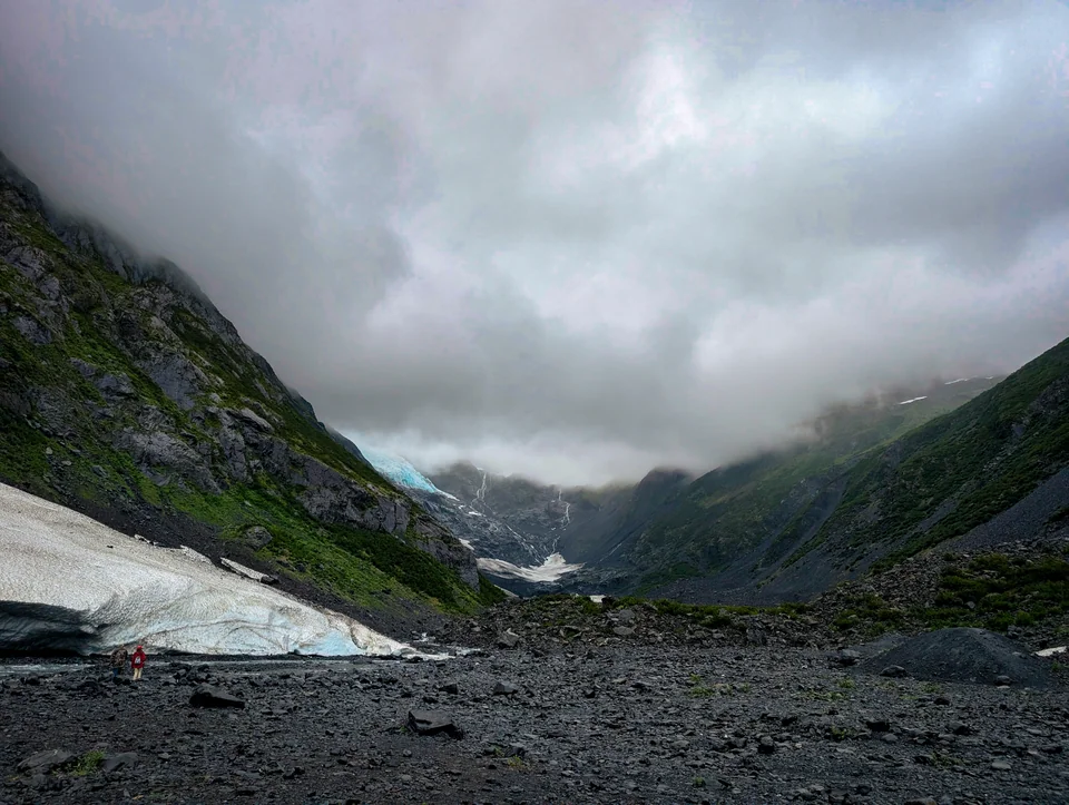 Rocky valley between mountains under a sky of low clouds.