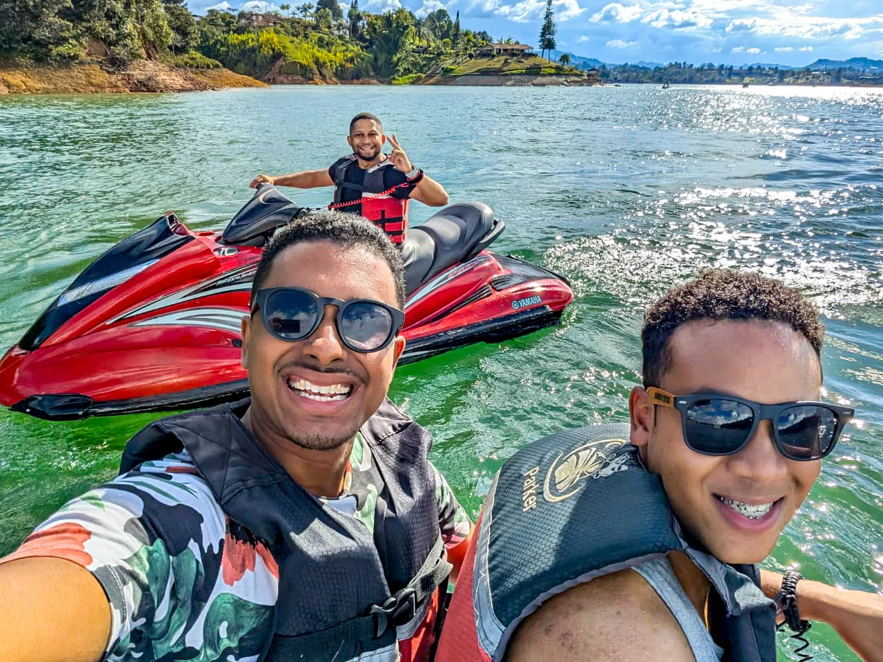 Friends in life jackets next to a jet ski